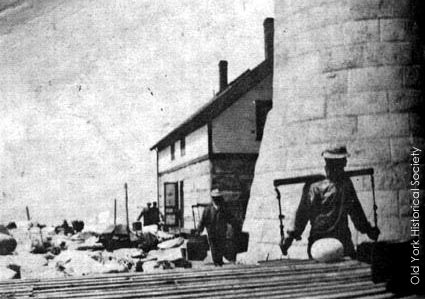 This photo from Friendly Edifices shows lighthouse tender crew members using yokes to carry supplies at the Boon Island Light Station. Courtesy of the Old York Historical Society.