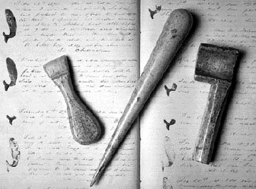 Working scrimshaw: shipboard tools made from sperm whale jawbone. Left to right: a sail creaser, a marlin spike about one foot in length, and a serving mallet used to wind spun yard around a rope. In the background is Leander S. Huntress' journal, kept onboard the Portsmouth whale ship Ann Parry and now in the Portsmouth Athenaeum. (Item in private collection, photo courtesy of Portsmouth Marine Society) SeacoastNH.com