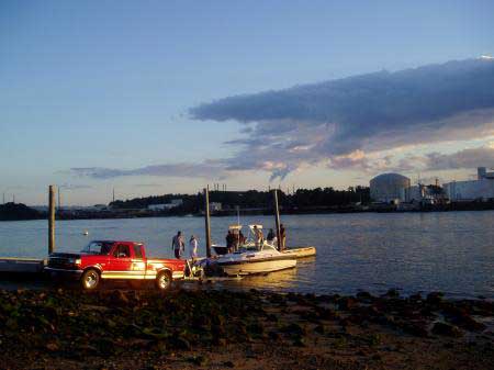 Boats arrive at the basin at sunset with Portsmouth across the river (c) SeacoastNH.com